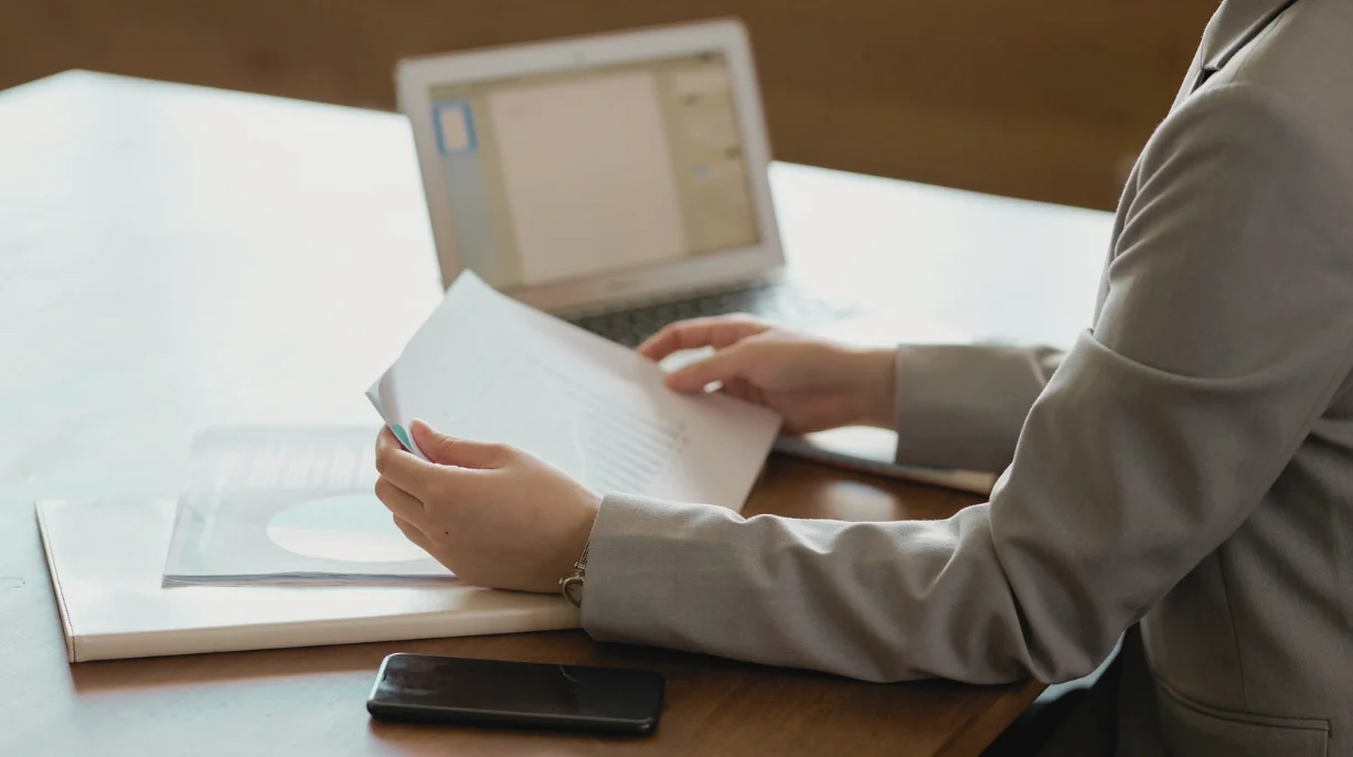 Malaysian SME business owner reviewing government grant documents in an office